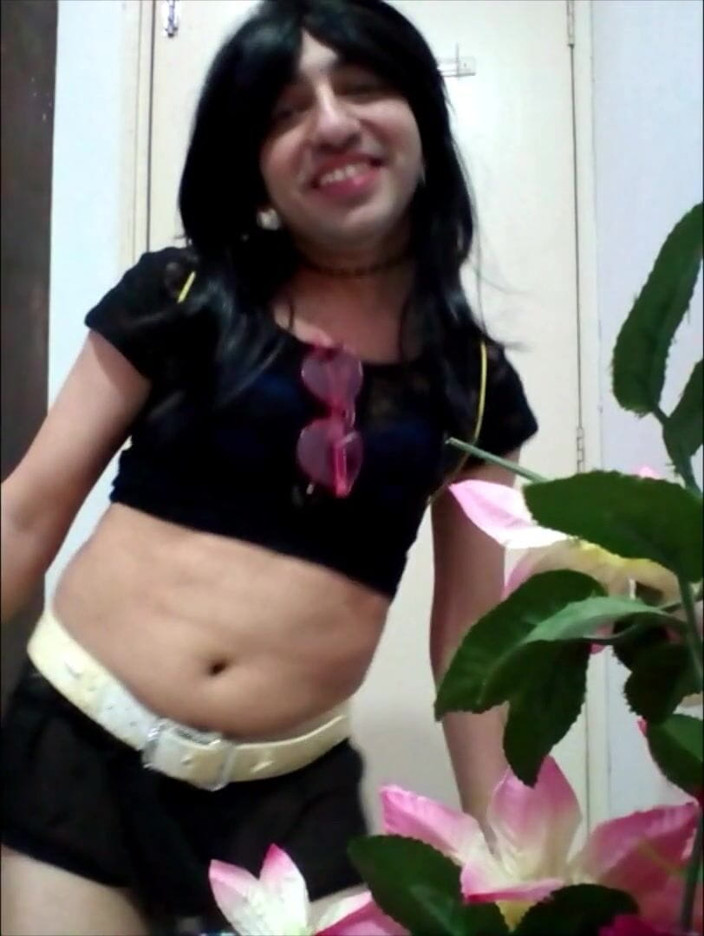 Cute & Nude Crossdresser: Сладкий кроссдрессер-сисси в сексуальном черном кроп-топе и короткой юбке с розовыми очками, белым поясом и кольцом для волос.