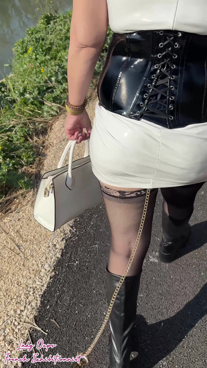 Lady Oups: Utomhusgå-in: En latexminiklänning med ett koppel och ett koppel runt...