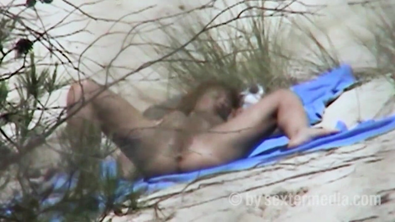 Sextermedia by Pete: Une beauté rousse se gode la chatte sur la plage...