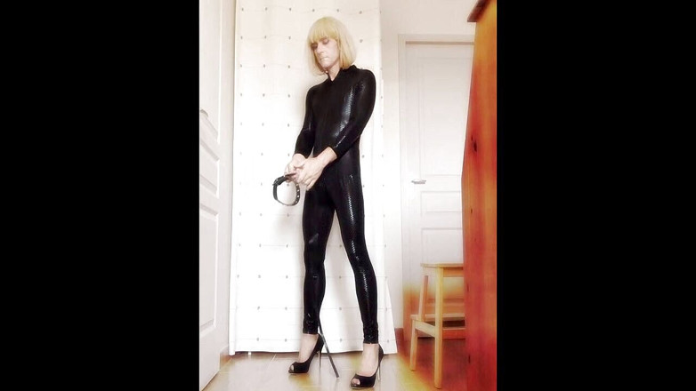 Faustine: Crossdresser Faustine vinyl catsuit với vòng cổ.